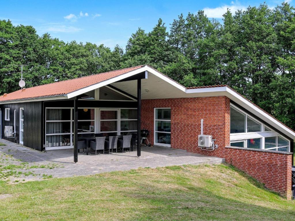 ein Backsteinhaus mit einer großen, offenen Terrasse in der Unterkunft Four-Bedroom Holiday home in Hadsund 25 in Nørre Hurup