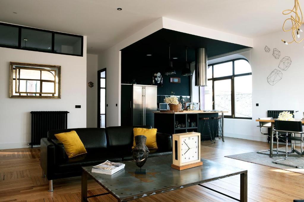 - un salon avec un canapé noir et une table dans l'établissement Gran loft en los pinares de Covaleda, Soria, à Covaleda