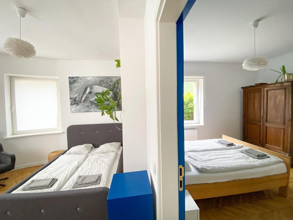 ライツァにあるApartamenty Rajczaのベッド2台とテーブルが備わる客室です。