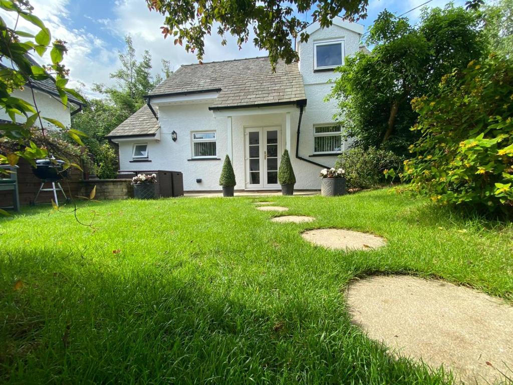 una casa con un patio verde con rocas en el césped en Lakeside Lodge, en Bassenthwaite Lake