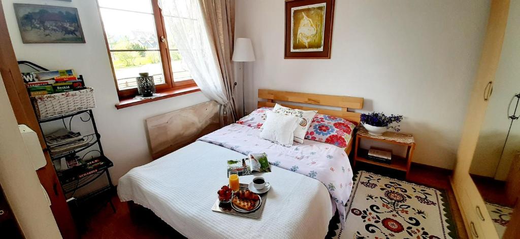 a bedroom with a bed with a tray of food on it at Apartament Vintage in Nowe Bystre