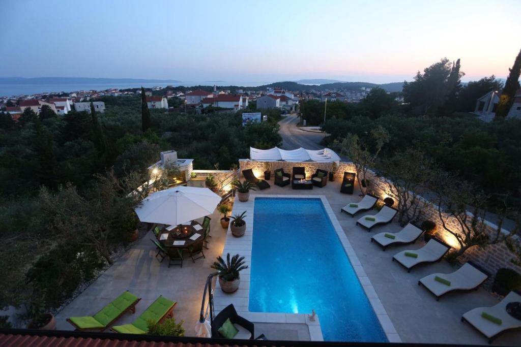 een uitzicht over een zwembad met stoelen en parasols bij Holiday Home Villa Di in Trogir
