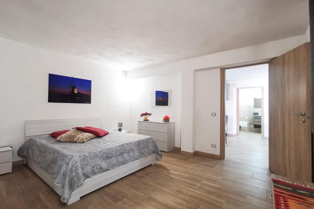ein weißes Schlafzimmer mit einem Bett und einem Flur in der Unterkunft Sole di Sicilia in Pizzolungo
