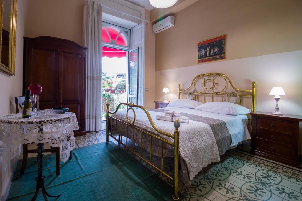 ポンペイにあるSweet Suite V&Vのベッドルーム1室(ベッド1台、テーブル、窓付)