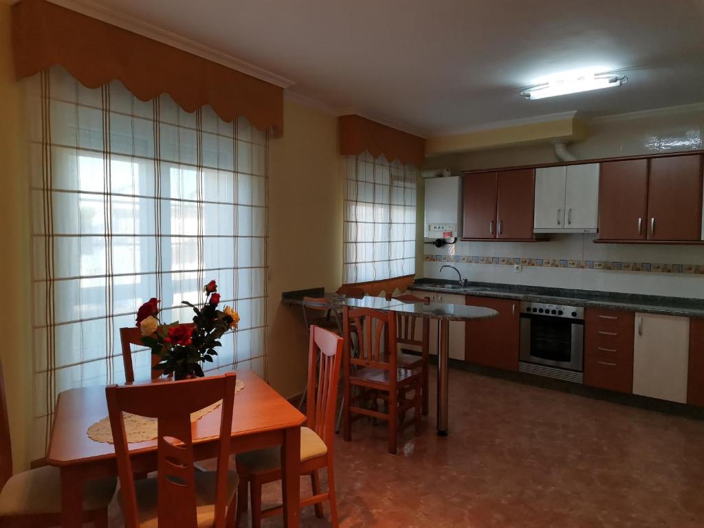 a kitchen with a table and chairs and a dining room at Apartamento próximo a Playa Llas in Foz