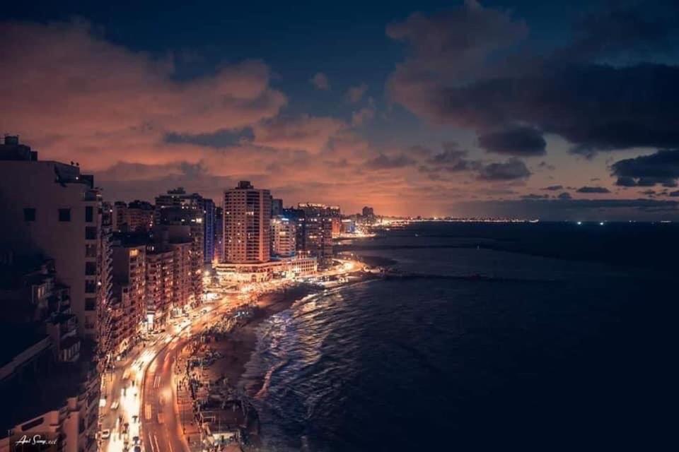 uma cidade à noite com luzes na praia em Breathtaking Wide Seaview Apartment em Alexandria