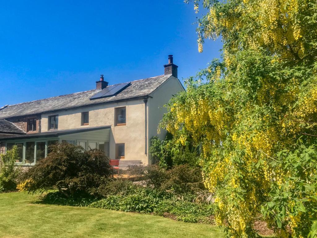 una gran casa blanca con patio en Low Garth Cottage, en Penruddock