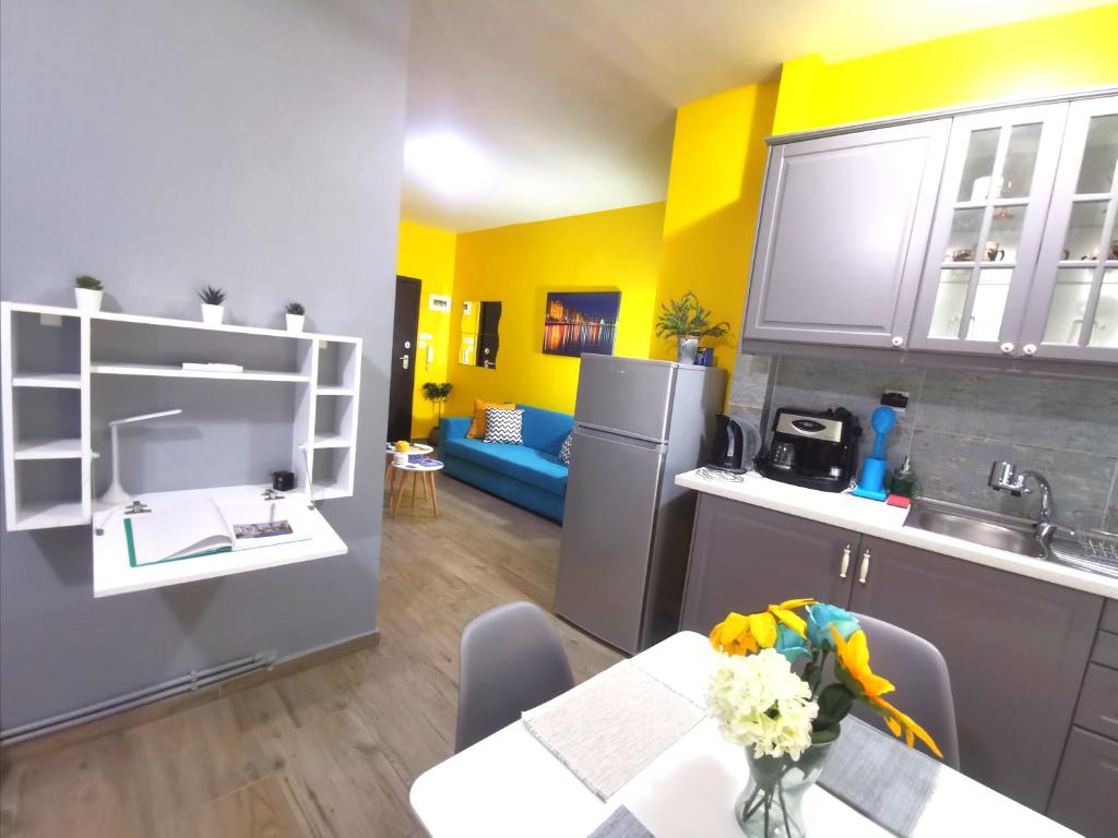 a kitchen with a table and a kitchen with yellow walls at N&N's Luxurious Suite #WhiteTower in Thessaloniki