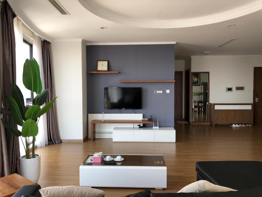 een woonkamer met een bank en een tv bij Vinhomes Royal City Apartment 3 Br in Hanoi