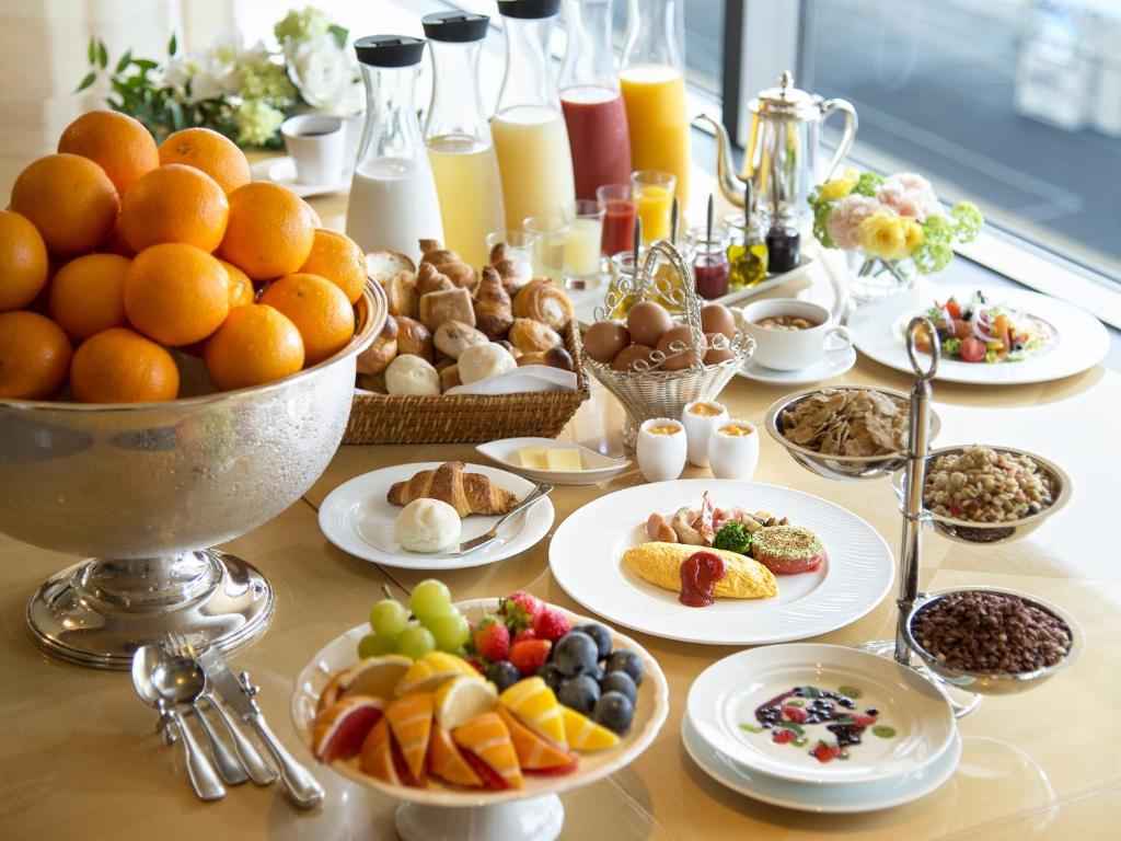 a table filled with plates of food and fruit at ANA Crowne Plaza Hotel Grand Court Nagoya by IHG in Nagoya