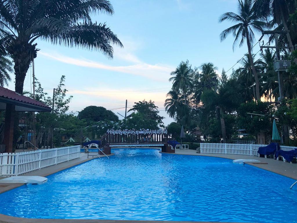 a large swimming pool with palm trees in the background at Ban Krut Resort in Ban Krut