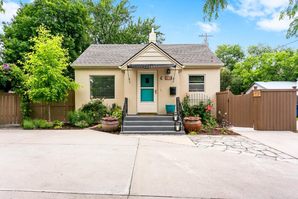 a house with a wooden fence and a driveway at North End Cottage in Boise
