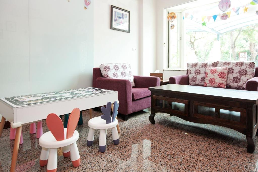 a living room with a couch and a table and chairs at Hualien Lidu House in Hualien City