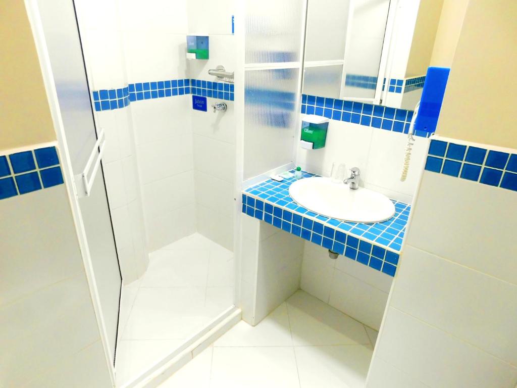 a bathroom with a sink, mirror, and toilet at Hotel Acqua Medellín in Medellín