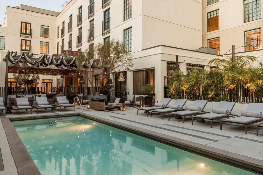 a hotel pool with lounge chairs and a building at Kimpton La Peer Hotel West Hollywood, an IHG Hotel in Los Angeles