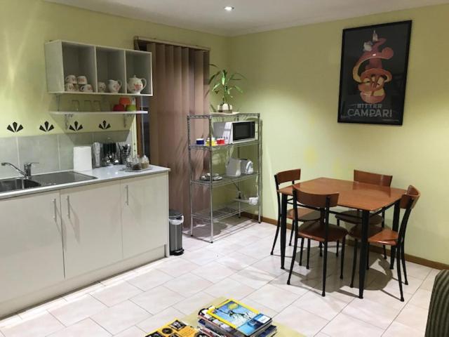 cocina y comedor con mesa y sillas en Effie Court en Springvale South