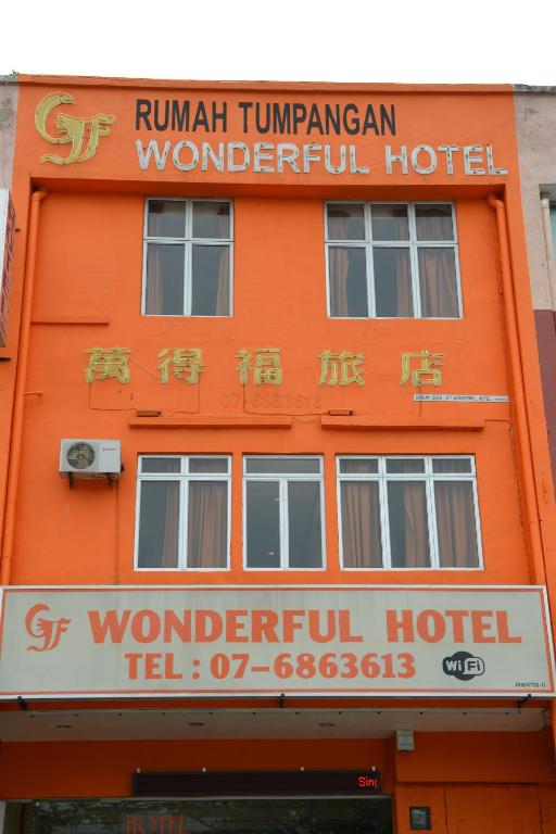 an orange building with a sign for a hotel at GF WONDERFUL HOTEL in Pontian Kecil