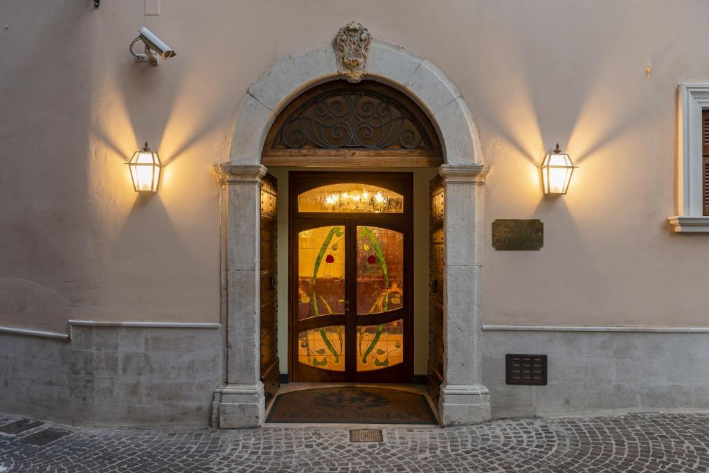 uma entrada para um edifício com uma grande porta de vidro em Hotel Rojan em Sulmona