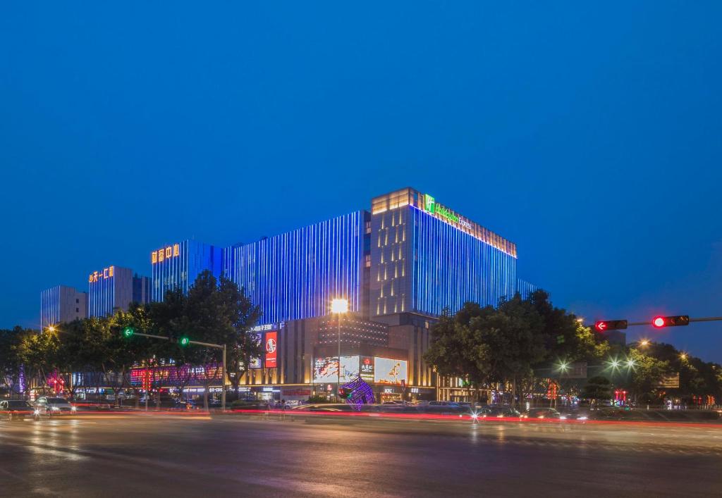 un edificio de noche con una calle delante en Holiday Inn Express Qingdao Chengyang Central, an IHG Hotel, en Qingdao