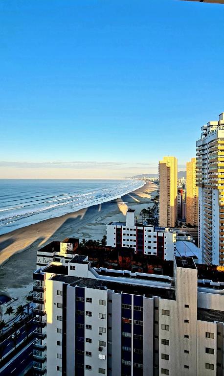 a view of a city with the beach and buildings at Requinte e sofisticação in Praia Grande