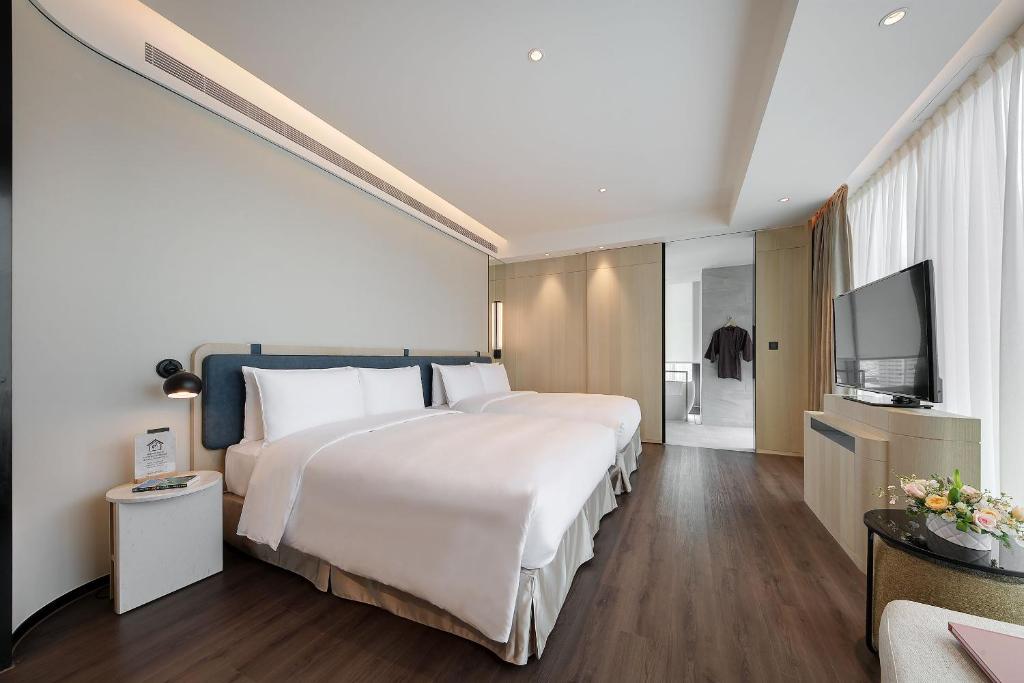 Postel nebo postele na pokoji v ubytování Jasper Young Hotel Banqiao