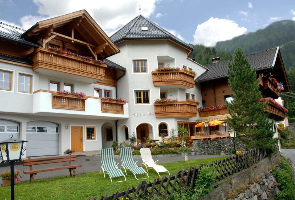 a large house with chairs in front of it at Sagritzerwirt in Großkirchheim