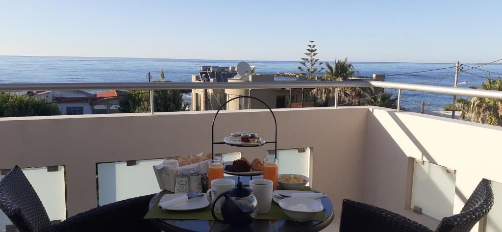 a table on a balcony with a view of the ocean at Sevach Apartments in Kalamaki Chanion