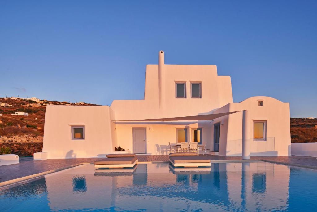 een wit huis met een zwembad ervoor bij Villa Rodakes in Vourvoúlos