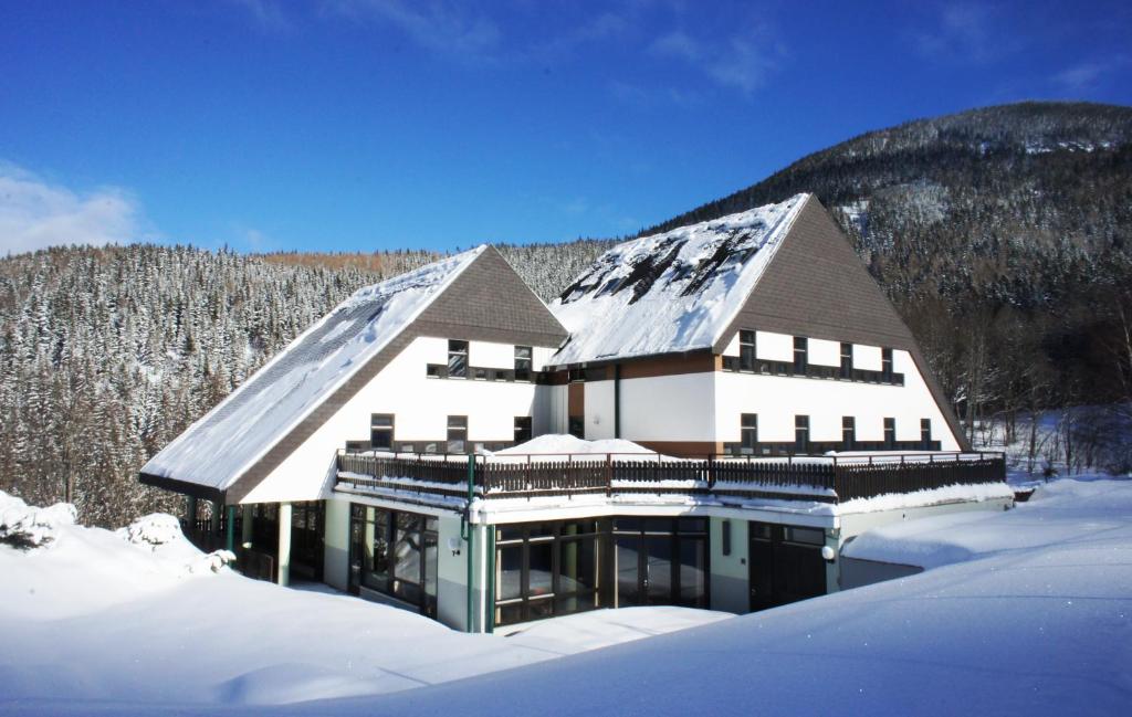 ein großes weißes Haus mit Schnee auf dem Dach in der Unterkunft Junges Hotel Annaberg in Annaberg