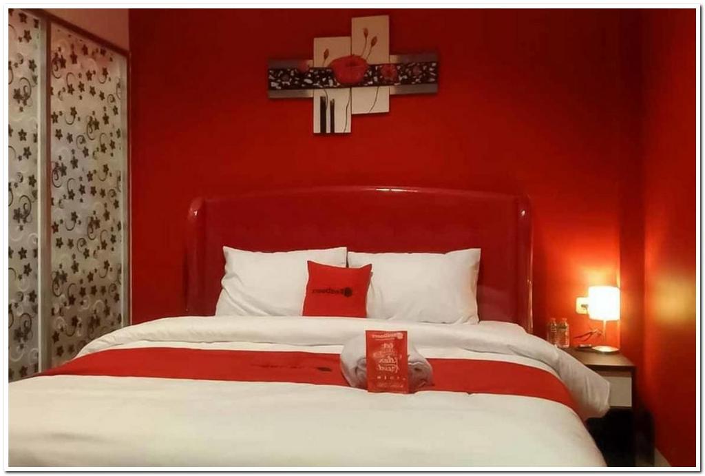 a red bedroom with a bed with a red wall at RedDoorz @ Sindangbarang Bogor in Bogor