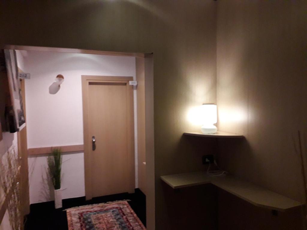 a bathroom with a door and a light on the wall at Hotel Vittoriano in Turin