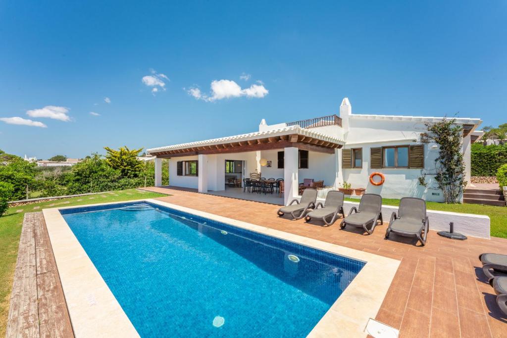 een villa met een zwembad en een huis bij Bini Nura in Binibeca