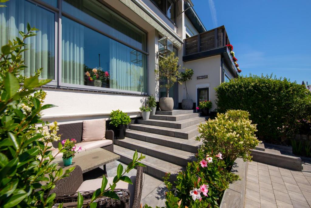 una casa con escaleras y plantas delante de ella en Hotel La Rosa Amsterdam Beach, en Zandvoort