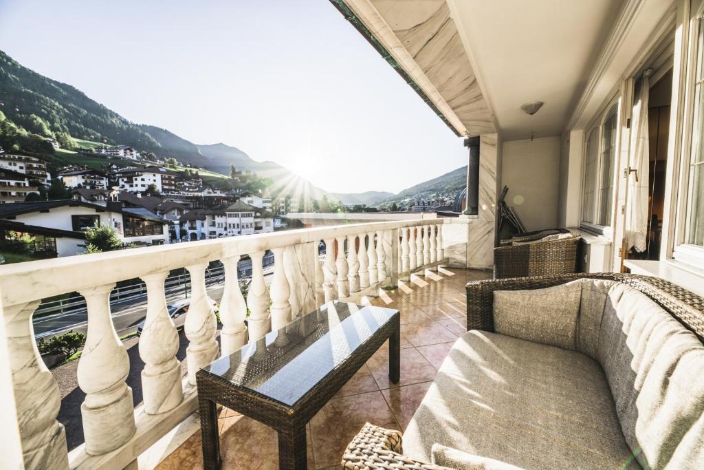 balcón con sofá y vistas a la ciudad en Apartments Villa Venezia Luxury en Ortisei