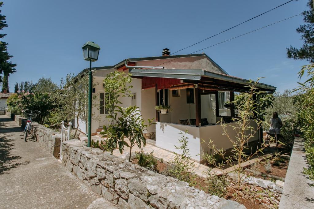 a small house next to a stone wall at Apartmani Melem in Stari Grad
