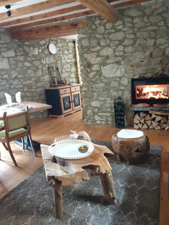 sala de estar con mesa y chimenea en La Petite Chapelle, en Font-Romeu