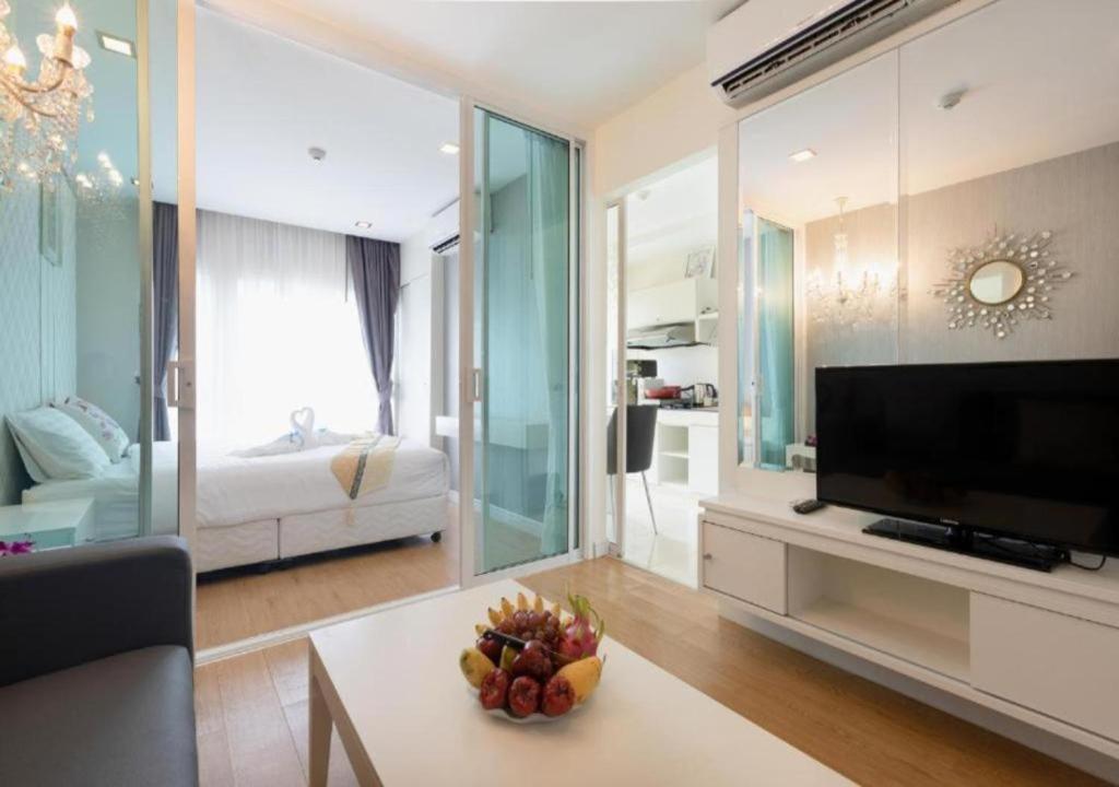 una sala de estar con TV y una habitación con cama en Backpacker Street Airport Place, en Nai Yang Beach