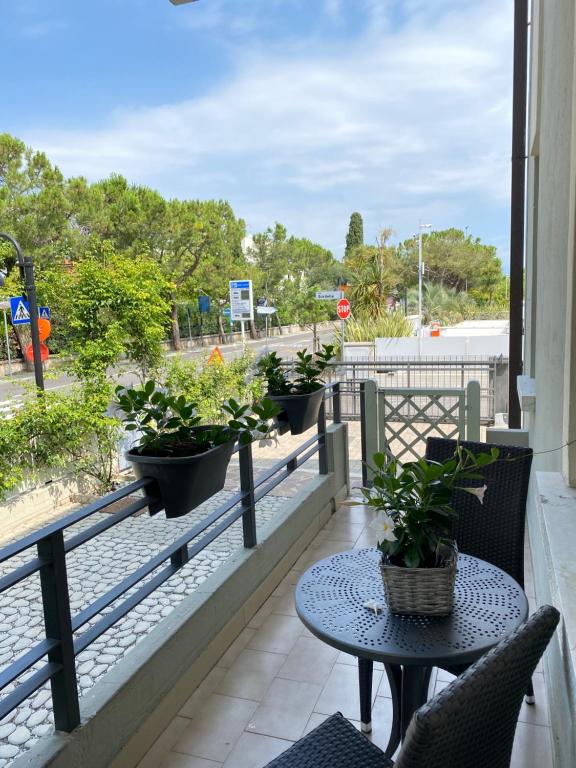 a balcony with a table and potted plants on it at Apartments Peninsula in Sirmione