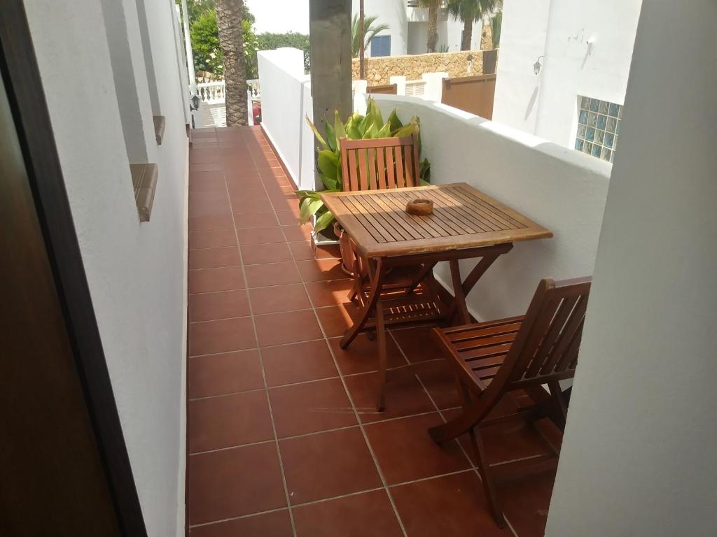 un pequeño balcón con mesa y sillas de madera en Habitaciones Martín, en San José
