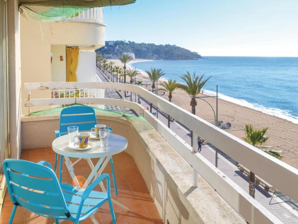 a table and chairs on a balcony with a view of the beach at Apartament Blue Lloret de mar in Lloret de Mar