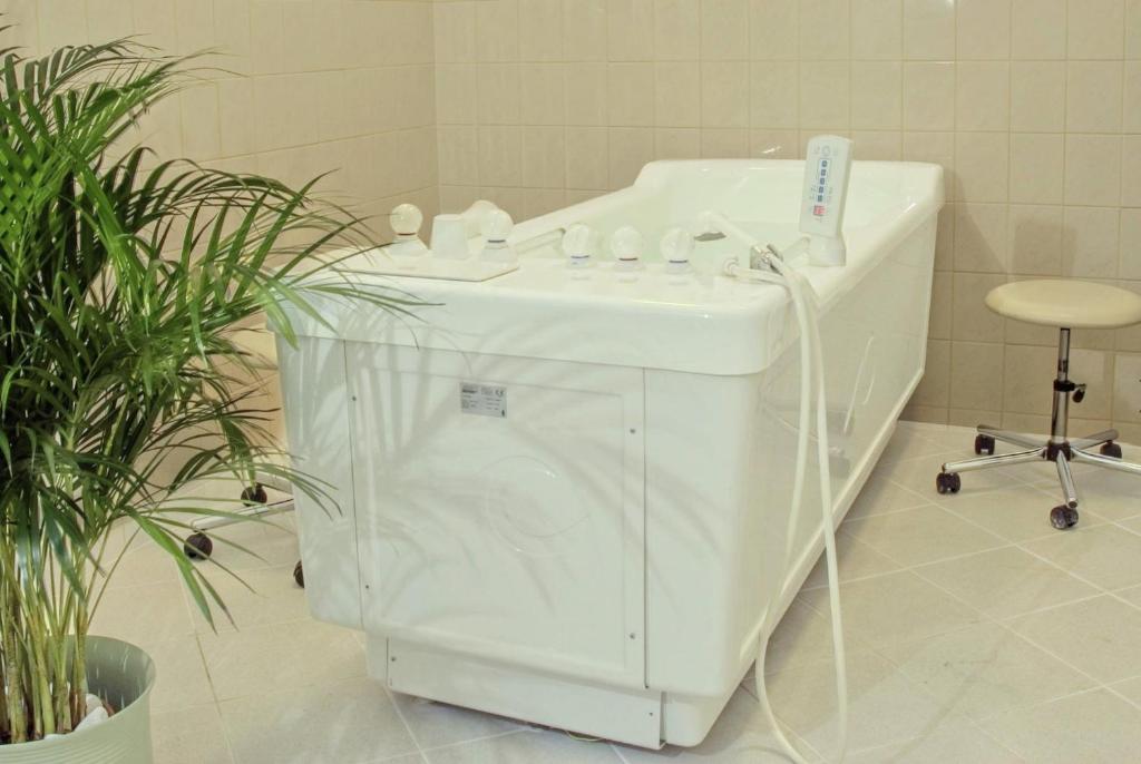 a white bath tub sitting next to a sink at Interhotel Central in Karlovy Vary