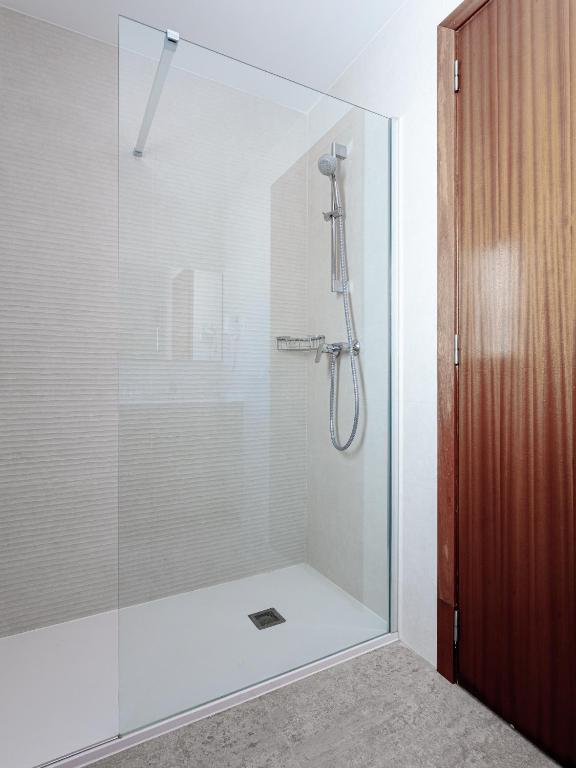 a shower with a glass door in a bathroom at Hostal Vila del Mar in Lloret de Mar