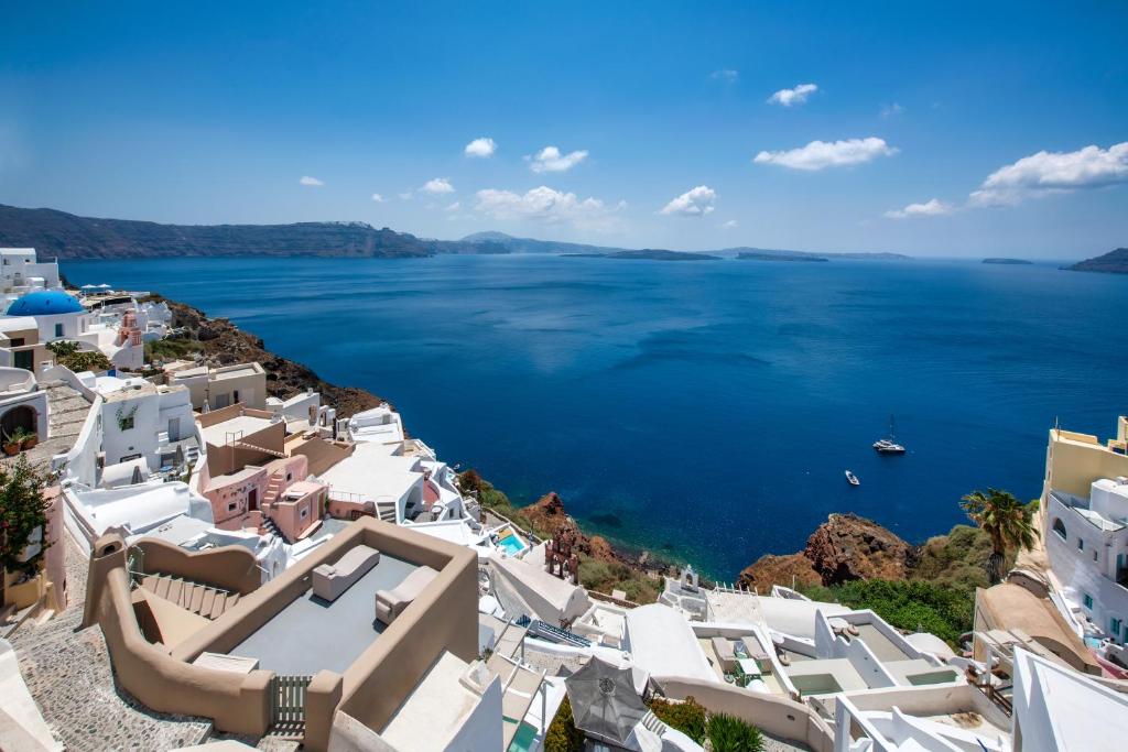 a view of the ocean from a town with white buildings at Kaleidoscope Oia Suites in Oia