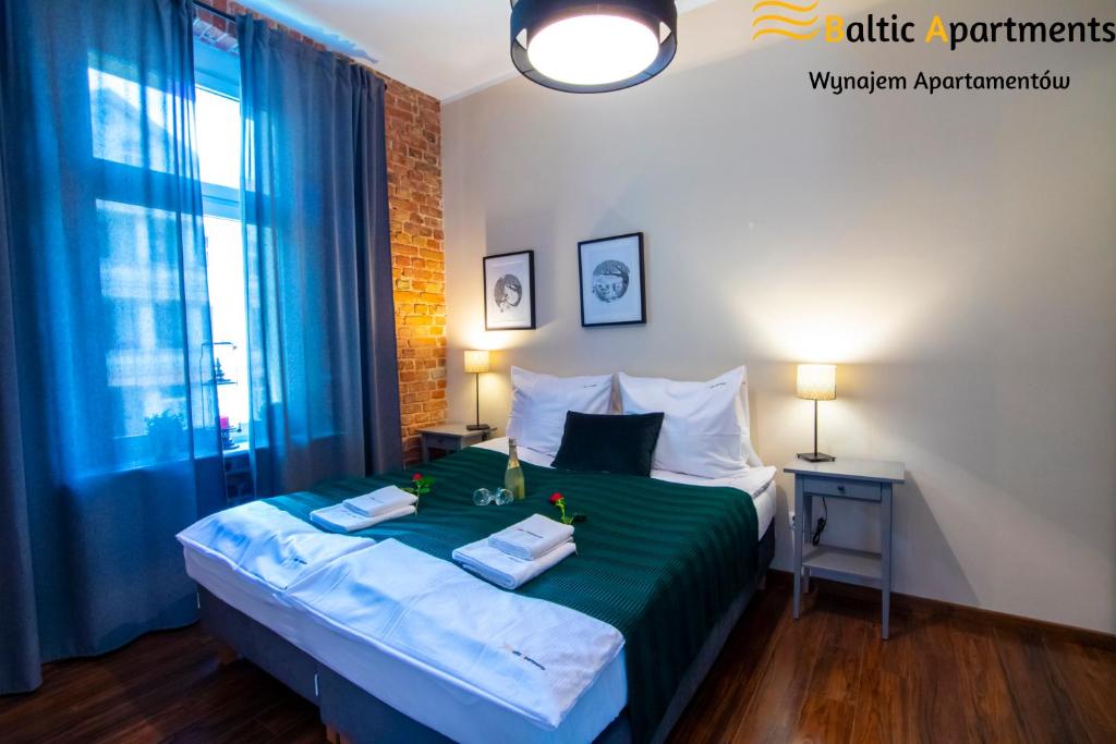 a bedroom with a bed with a green comforter at Baltic Apartments - Apartamenty Loft in Świnoujście