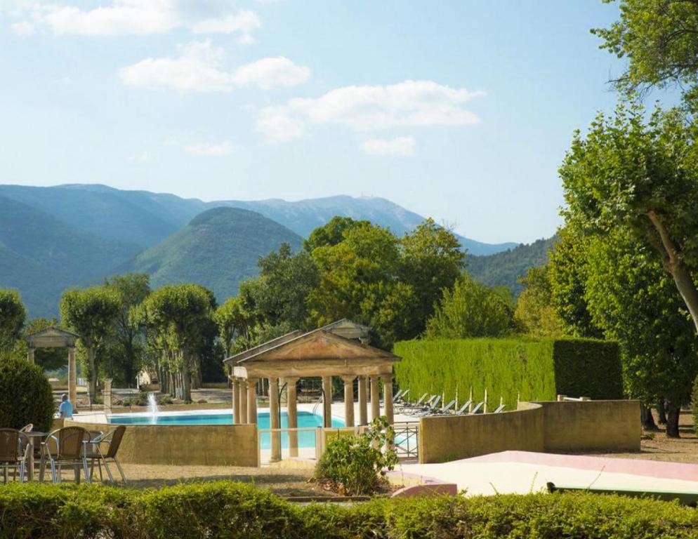 a swimming pool with a gazebo and mountains in the background at Appartement Bellevue du Ventoux in Montbrun-les-Bains