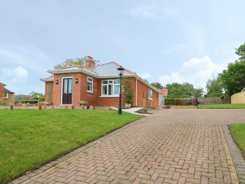 a brick house with a brick driveway at Waverley in Spilsby