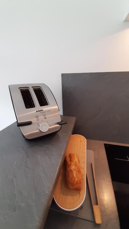 a toaster sitting on a counter next to a plate of food at PAREE D EAU 104 - Résidence avec piscine - Appartement rez de jardin 1 chambre in Notre-Dame-de-Monts