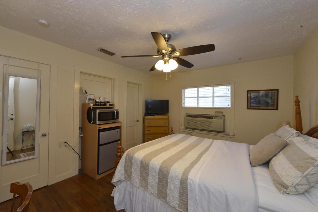 a bedroom with a bed and a ceiling fan at Shiner Country Inn in Shiner