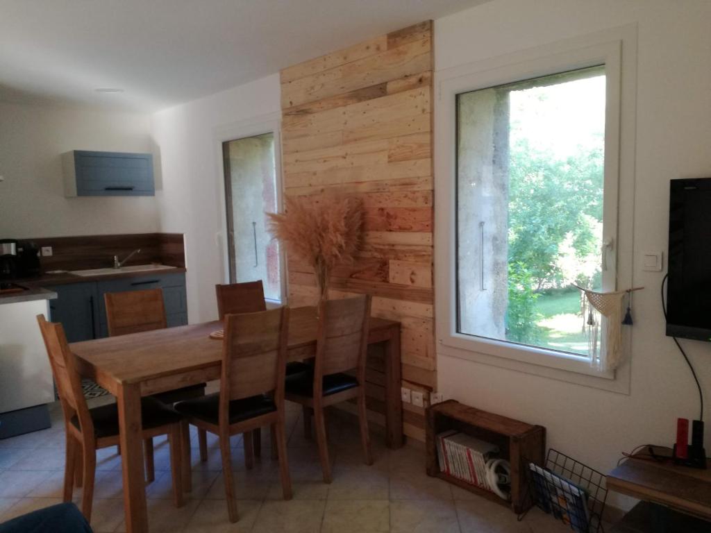 ein Esszimmer mit einem Holztisch und einem Fenster in der Unterkunft L'Echevine en vercors in Échevis