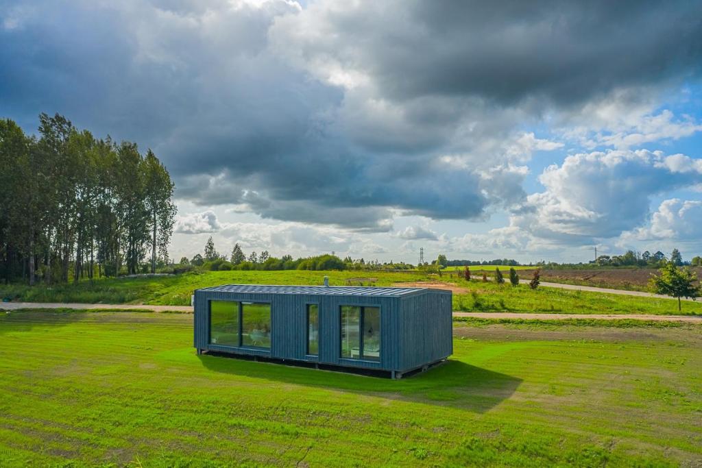 una pequeña casa azul en un campo verde en TAURO TROBA “The Ox Shelter” en Stragutė